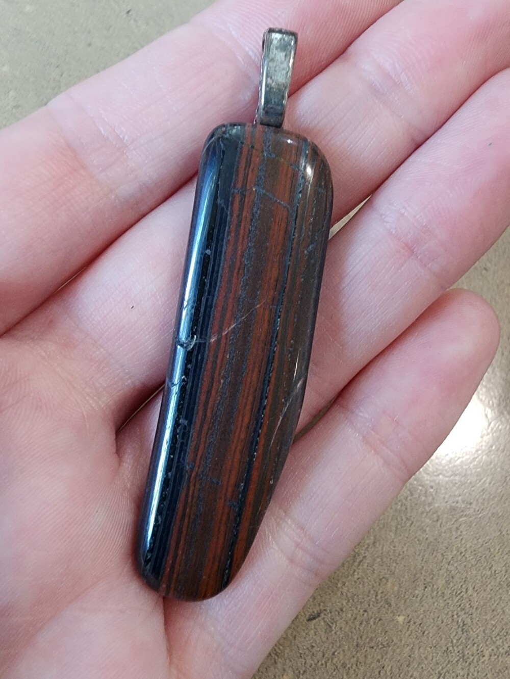Red and Black Stone Pendant With Silver Bail